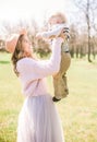 Young attractive girl with blond hair with a small toddler boy in spring in a lush garden Royalty Free Stock Photo