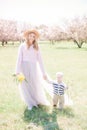 Young attractive girl with blond hair with a small toddler boy in spring in a lush garden Royalty Free Stock Photo