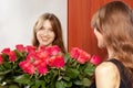 Young attractive girl with a bouquet of red roses is reflected in the mirror Royalty Free Stock Photo