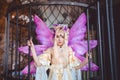 Young attractive girl dressed as fairy in the cage