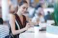 Young attractive girl with glasses and notepad smiling in cafe Royalty Free Stock Photo