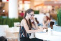 Young attractive girl in glasses smiles in cafe Royalty Free Stock Photo