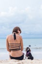 Young attractive girl with her pet dog Beagle at the beach of tropical island Bali, Indonesia. Happy moments. Royalty Free Stock Photo