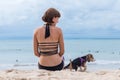 Young attractive girl with her pet dog Beagle at the beach of tropical island Bali, Indonesia. Happy moments. Royalty Free Stock Photo