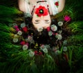 A young attractive girl lies on a lawn among dandelions. She holds a flower in her mouth. Spring mood Royalty Free Stock Photo