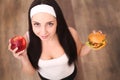 Young attractive girl making choice between healthy and harmful food Royalty Free Stock Photo