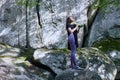 Young attractive girl in the mountains is holding a yoga mat