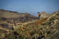 Young and attractive girl in orange shirt and blue leggings is hiking by the tourist`s trail. Royalty Free Stock Photo