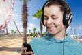 Young attractive girl with a player on a city street on a clear sunny day listening to music. Royalty Free Stock Photo