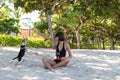 Young attractive girl playing with her pet dog Beagle at the beach of tropical island Bali, Indonesia. Happy moments. Royalty Free Stock Photo