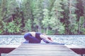 Young attractive girl practicing yoga, sitting in Child exercise, Balasana pose on the lake. The concept of appeasement, healthy