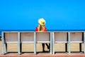 Young attractive girl in a red dress sitting on a bench near the sea in the summer, Batumi, Georgia Royalty Free Stock Photo