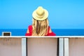 Young attractive girl in a red dress sitting on a bench near the sea in the summer, Batumi, Georgia Royalty Free Stock Photo