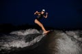 Young attractive girl riding on the orange wakesurf in the night Royalty Free Stock Photo