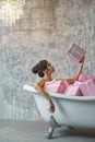 Girl sitting in the bath with gifts Royalty Free Stock Photo