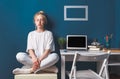 Young Attractive Girl Sitting In Lotus Position Near Desktop Work Place