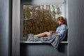 Young attractive girl on the window sill . Royalty Free Stock Photo