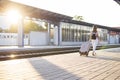 Attractive girl is standing with luggage at the station and waiting for the train, the student is going on a trip, she is walking Royalty Free Stock Photo