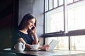 Young attractive girl talking on mobile phone in coffee shop Royalty Free Stock Photo