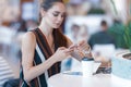 Young attractive girl uses phone in cafe Royalty Free Stock Photo