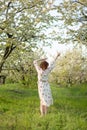 Young attractive girl walks in spring green park enjoying flowering nature Royalty Free Stock Photo