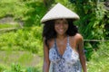 Young attractive happy afro american black woman 30s exploring rice fields forest and jungle in Bali wearing rural traditional Asi