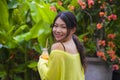 Young attractive and happy Asian Chinese girl having fun in garden outdoors drinking healthy orange juice with straw playful Royalty Free Stock Photo