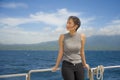 Young attractive and happy Asian Chinese woman on excursion ship or ferry enjoying sea breeze on summer holiday sea boat trip