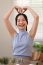 Young attractive happy Asian female student standing in the living room smiling and looking at the camera while working Royalty Free Stock Photo