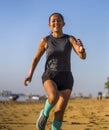 Young attractive and happy Asian Indonesian woman in her 40s running happy on the beach enjoying morning jogging workout cheerful Royalty Free Stock Photo