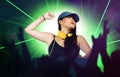 Young attractive and happy Asian Japanese DJ woman remixing using deejay gear and headphones at night club with lights background Royalty Free Stock Photo