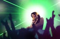 Young attractive and happy Asian Japanese DJ woman remixing using deejay gear and headphones at night club with lights background Royalty Free Stock Photo