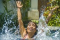 Young attractive and happy Asian woman in bikini playing in swimming pool splashing water cheerful having fun enjoying Summer Royalty Free Stock Photo