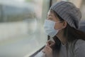 Young attractive and happy Asian woman in mask traveling on railcar in new normal virus time - sweet Chinese girl looking through Royalty Free Stock Photo