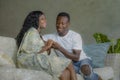 Young attractive and happy black African American couple relaxed at home sofa couch talking sweet enjoying together and smiling in