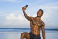 Young attractive and happy black African American sport man with athletic body and sixpack taking selfie photo with mobile phone