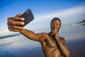 Young attractive and happy black African American sport man with athletic body and sixpack taking selfie photo with mobile phone