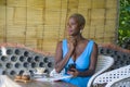 Young attractive and happy black afro american business woman working relaxed from beautiful coffee shop using mobile phone textin Royalty Free Stock Photo