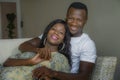 Young attractive and happy black afro American couple relaxed at home sofa couch talking sweet enjoying together and smiling in Royalty Free Stock Photo