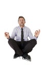 Young attractive happy businessman relaxing with hands in yoga position sitting on the floor Royalty Free Stock Photo