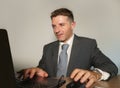 Young attractive and happy businessman in suit and necktie working on office laptop computer desk isolated on white background Royalty Free Stock Photo