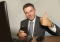 Young attractive and happy businessman in suit and necktie working on office laptop computer desk using mobile phone on isolated Royalty Free Stock Photo