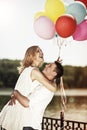 Young attractive happy couple with colorful ballons embracing an