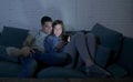 Young attractive and happy couple using internet app on mobile phone enjoying and laughing together sitting at home living room so Royalty Free Stock Photo