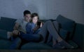 Young attractive and happy couple using internet app on mobile phone enjoying and laughing together sitting at home living room so Royalty Free Stock Photo