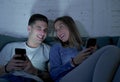 Young attractive and happy couple using internet app on mobile phone enjoying and laughing together sitting at home living room so Royalty Free Stock Photo