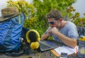 Young attractive and happy digital nomad man working outdoors with laptop computer cheerful and confident running business remote Royalty Free Stock Photo