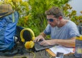 Young attractive and happy digital nomad man working outdoors with laptop computer cheerful and confident running business remote Royalty Free Stock Photo