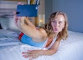 Young attractive and happy girl smiling cheerful and relaxed using internet social media app on mobile phone taking selfie photo p Royalty Free Stock Photo