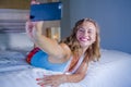Young attractive and happy girl smiling cheerful and relaxed using internet social media app on mobile phone taking selfie photo p Royalty Free Stock Photo